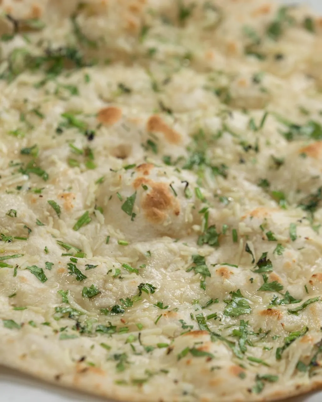 Garlic naan topped with garlic and chopped cilantro