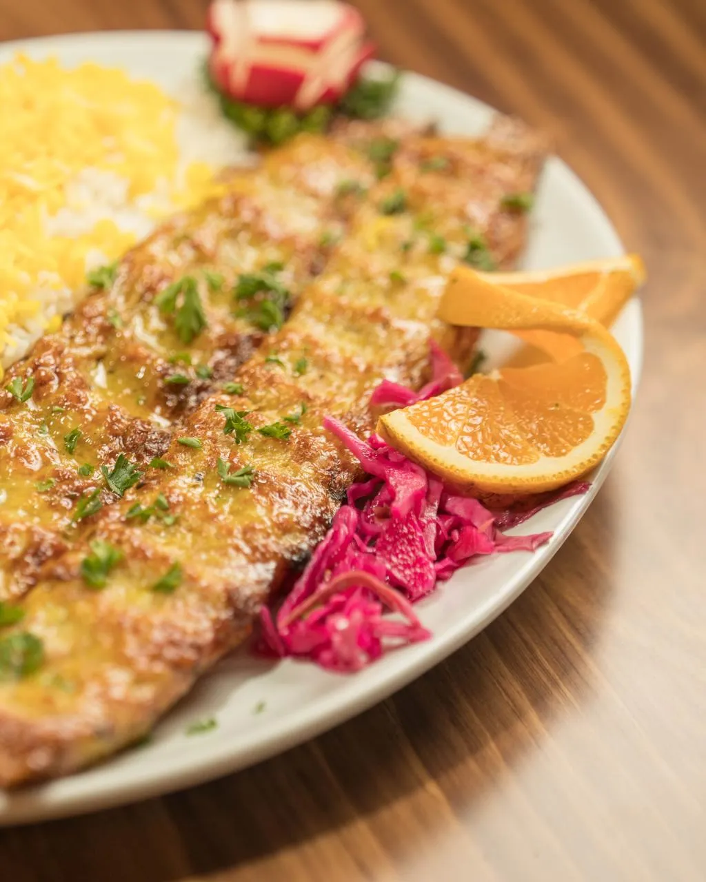 Chicken koobideh skewers beside saffron rice, pickled red cabbage and orange slices