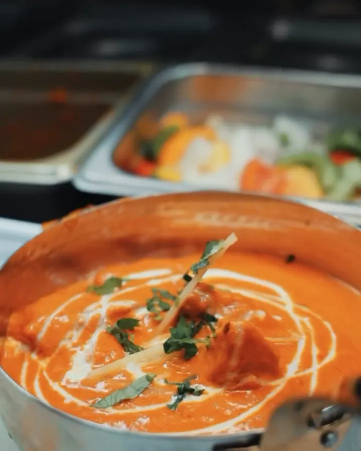 Butter chicken finished with a swirl of cream, in the pan
