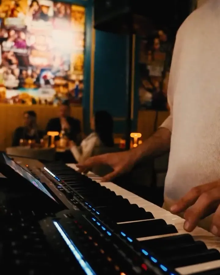 Live music at the keys under the film-poster wall