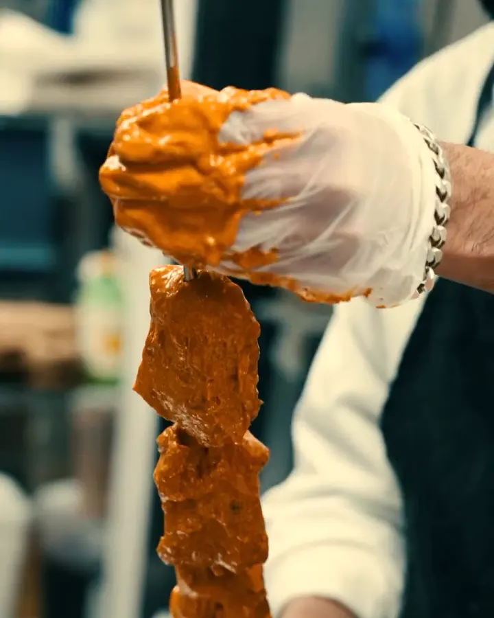 Spiced chicken threaded onto the tandoor skewer