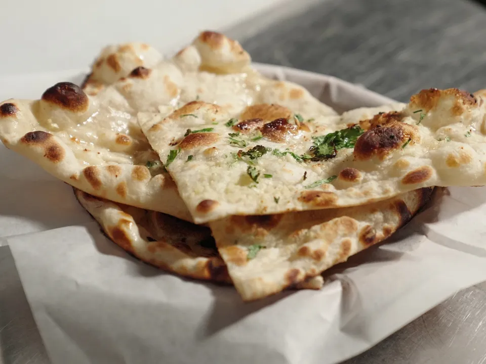 Garlic naan in a paper-lined basket