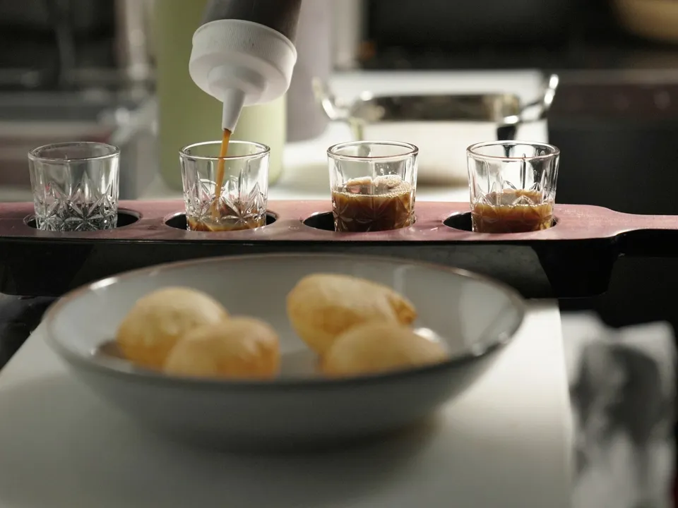 Pani puri: spiced water poured into shot glasses, the puris in a bowl